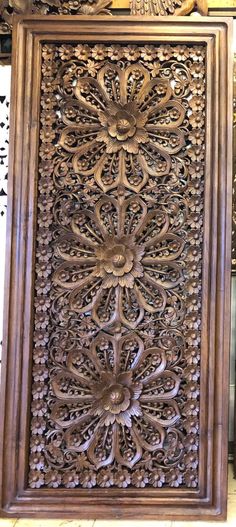 an ornate carved wooden panel on display in a store