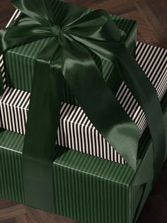 two green boxes with black and white striped wrapping on them, one has a bow at the top