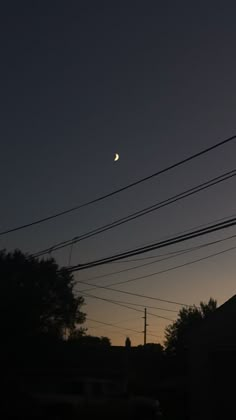 the sun is setting behind some power lines