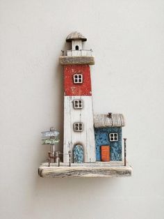 a small red and white lighthouse on a shelf