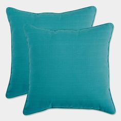 two teal colored pillows sitting next to each other