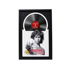 an old record with a woman pointing at the disc on it's side, in a black and white frame