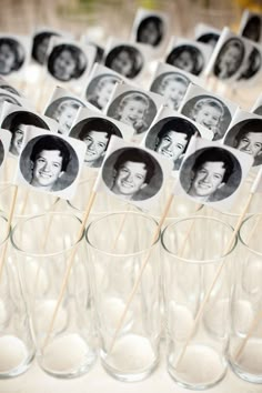 an arrangement of glasses filled with photos and toothpicks