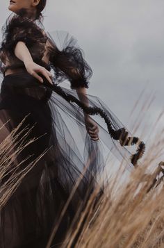 a woman is standing in the tall grass