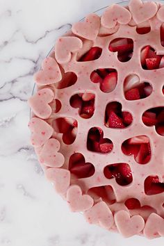 a pie with hearts cut out of it sitting on a table next to a marble counter top