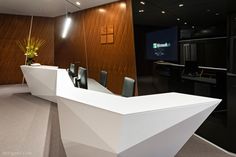 an office with wooden walls and white desks