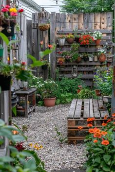 a wooden bench sitting in the middle of a garden filled with lots of plants and flowers