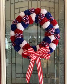 a red, white and blue wreath hanging on the front door