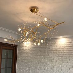 a chandelier hanging from the ceiling in a room with white brick wall and door