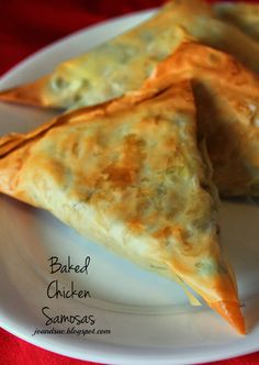 two pieces of baked chicken samskas on a white plate with red tablecloth