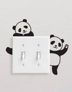 a light switch with a panda bear decal on the wall next to it's outlet