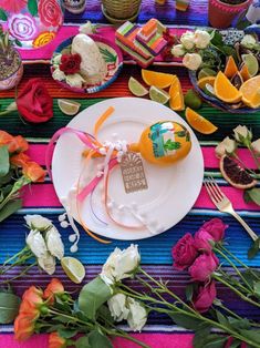 the table is decorated with flowers, fruit and other things to eat for an event