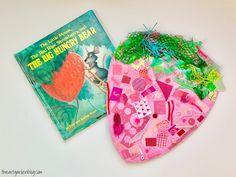 two children's books are laying on the table next to each other, one is covered in pink and green material