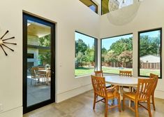 a dining room table with chairs and a clock mounted to the side of it's wall