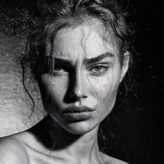 a black and white photo of a woman with freckles on her face looking at the camera