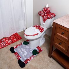 a white toilet sitting in a bathroom next to a red rug and wooden cabinet with drawers