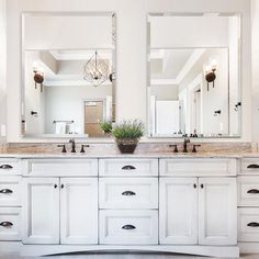 a white bathroom with double sinks and large mirrors on the wall above them is shown