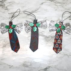 three ties with bows are hanging on a marble countertop in the shape of angels