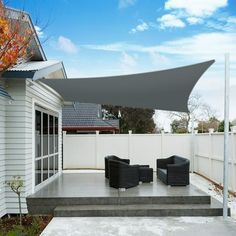 an outdoor patio with black chairs and a gray awning