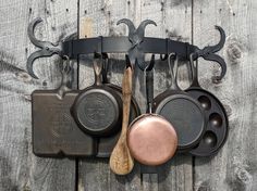 an assortment of cooking utensils hanging on a wall