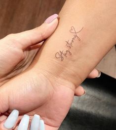 two people holding each other's hands with the word love written on their wrist