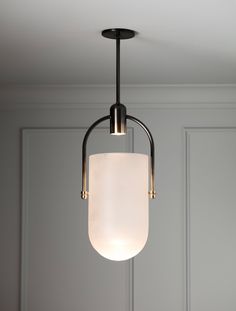 a light fixture hanging from the ceiling in a room with gray walls and white paneling