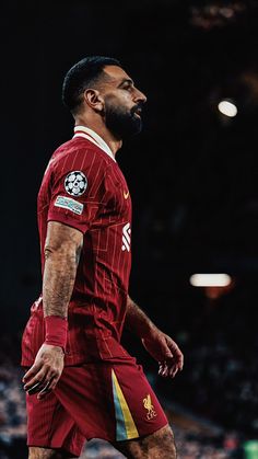 a man with a beard is wearing a red uniform and standing in front of a crowd