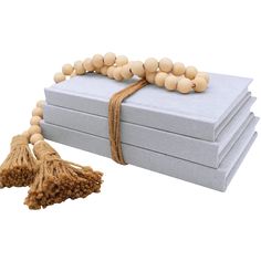 a set of three boxes with tassels and beads on them, sitting next to each other