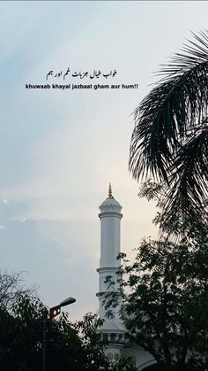 a tall white tower with a clock on it's side and trees in the foreground