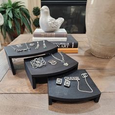 three pieces of jewelry sitting on top of a wooden table in front of a fireplace