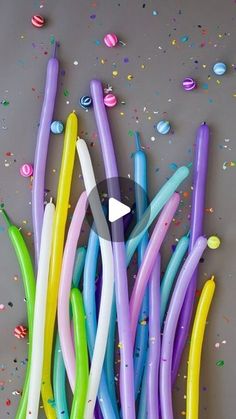 colorful balloons and confetti on a gray surface with streamers in the background