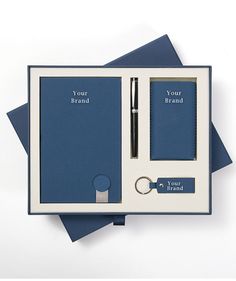 a blue and white box with two notepads, pen and keychain