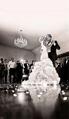 a black and white photo of a bride and groom on the dance floor