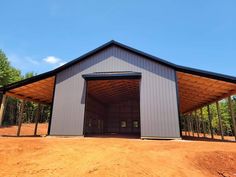 a large metal building sitting on top of a dirt field