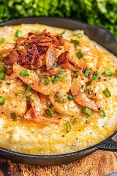 an omelet with bacon and chives in a cast iron skillet on a wooden table