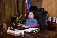 a woman sitting at a desk in front of a laptop computer and books on it