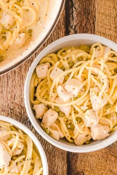 three white bowls filled with pasta and chicken on top of a wooden table next to another bowl