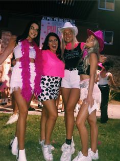 three women in pink and white outfits posing for the camera with one woman wearing short shorts