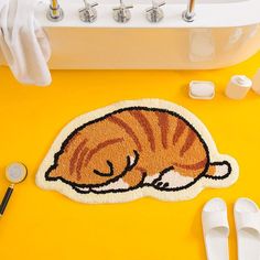 a bath mat with a cat sleeping on it next to other bathroom accessories and items