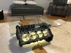 an engine block is sitting on the floor in front of a glass table with lights