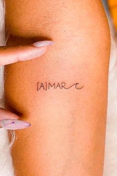 a woman's arm with the word amar written on it and her fingers