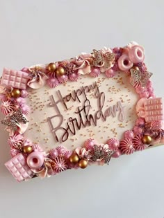 a birthday cake decorated with pink and gold decorations