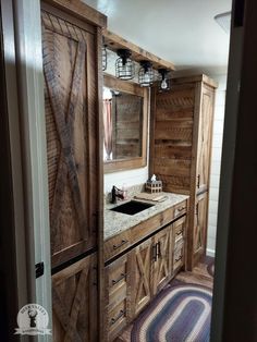 a bathroom with wooden cabinets and marble counter tops, along with a rug on the floor