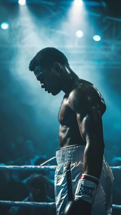 a man standing in the middle of a boxing ring with his hands on his hips