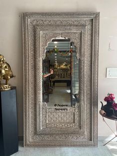 a large silver mirror sitting on top of a table