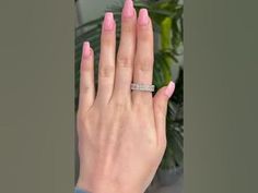 a woman's hand with pink nail polish and a diamond ring