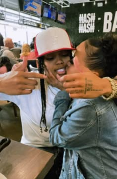 two women are taking a selfie in a restaurant with one pointing at the camera