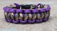 a purple and black paracorte bracelet sitting on the ground