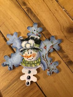 a snowman ornament sitting on top of a wooden floor