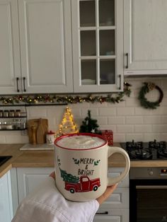 someone is holding up a mug in the kitchen